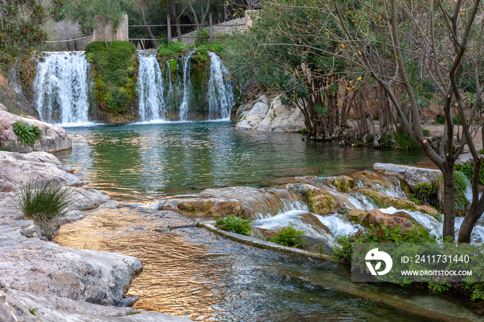 Waterfall with green water pond. Toll del Baladre, Las Fuentes del Algar / Algar fountains, Callosa de Ensarria, Alicante province, Spain.