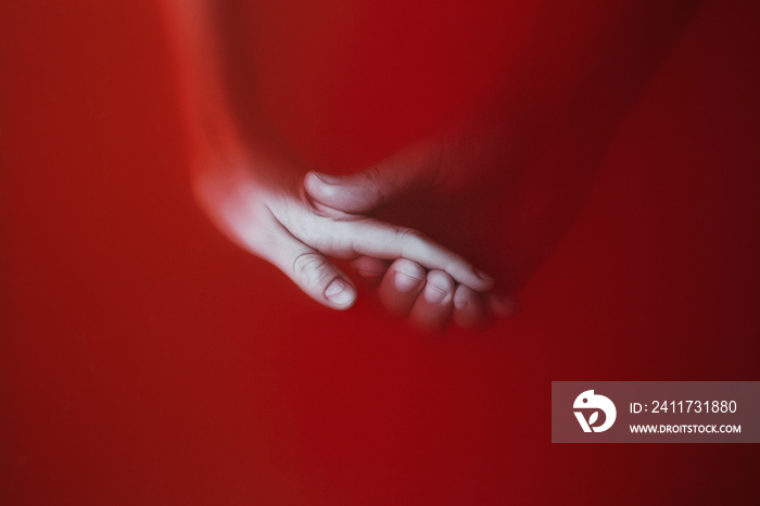 a man gently holding the hand of a girl in the red bloody water , the concept of the power of love and betrayal