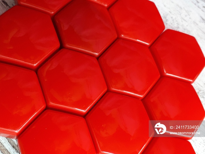 abstract red background in the form of bee honeycombs on a wooden surface