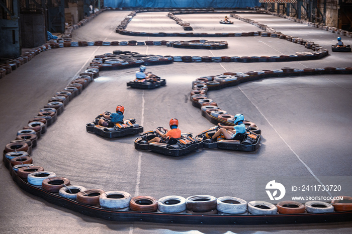 Three guys racing with go karts indoors