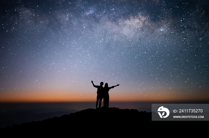 Silhouette of couple of lovers watched the star and milky way alone on top of the mountain. He enjoyed traveling and was successful when he reached the summit