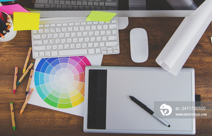 Modern office workplace with digital tablet, notepad, colorful pencils, glasses, in morning