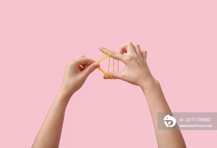 Woman with yellow rubber bands on pink background