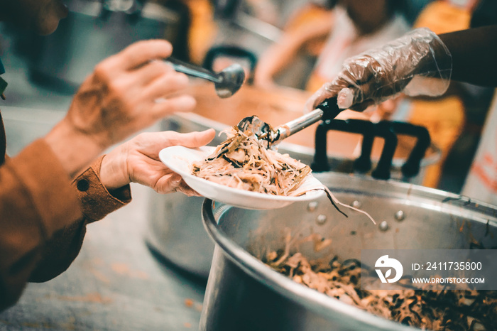 Homeless people receive delicious charity food from volunteers: concept of helping by donating food