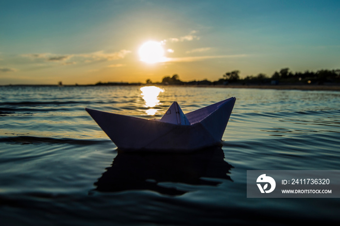 paper boat in the evening at sea sunset