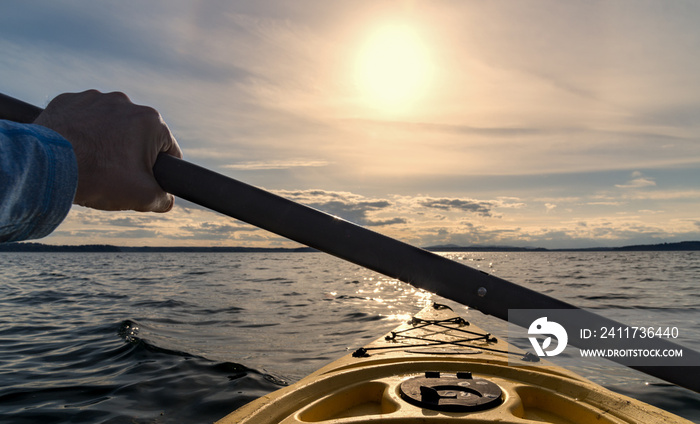 Point of view kayak paddling out to sea at sunset