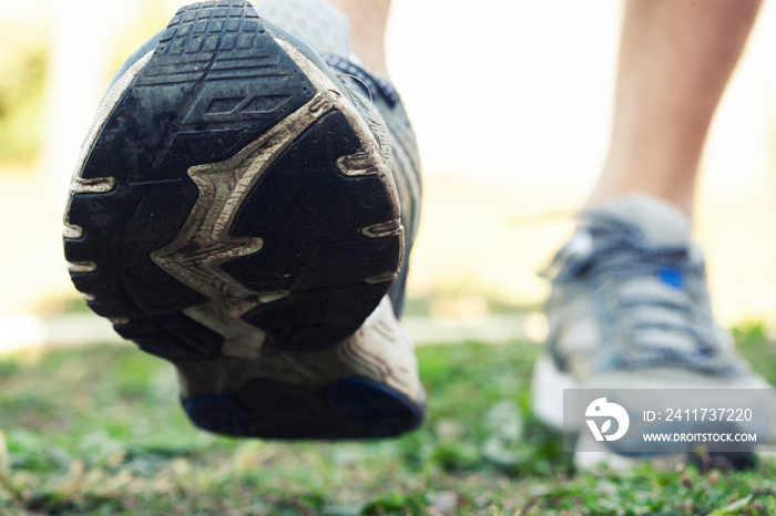 Closeup view of runner’s shoes running throug the countryside