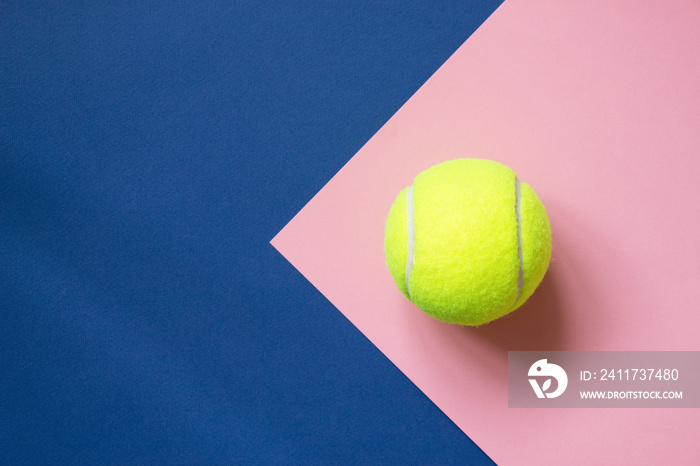 Tennis ball on blue and pink paper background. Concept sport. Copy space