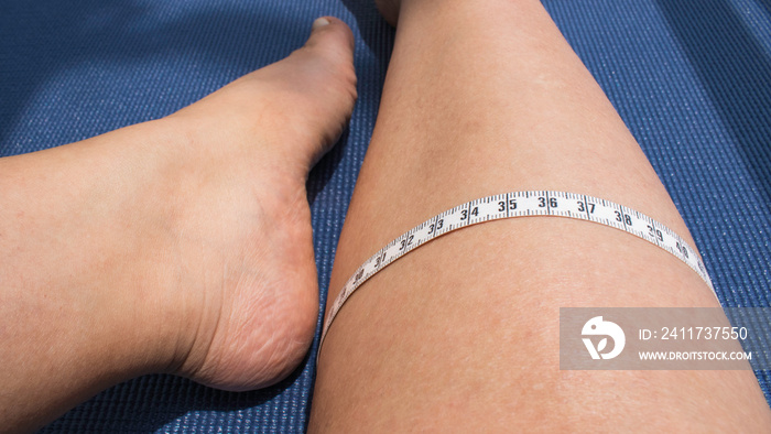 Person measuring the thickness of his leg