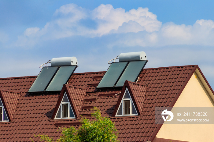 Solar water heaters on a residential house rooftop. Renewable energy for house