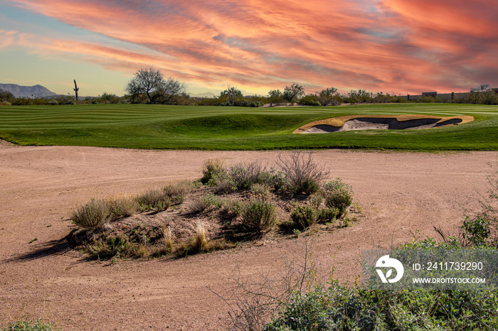 Dramatic sunset with clouds in the desert over a golf course fairway