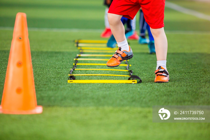 Kid soccer player Jogging and jump between marker for football training. Ladder drills exercises for football soccer team. Kid player exercises on ladder drills.