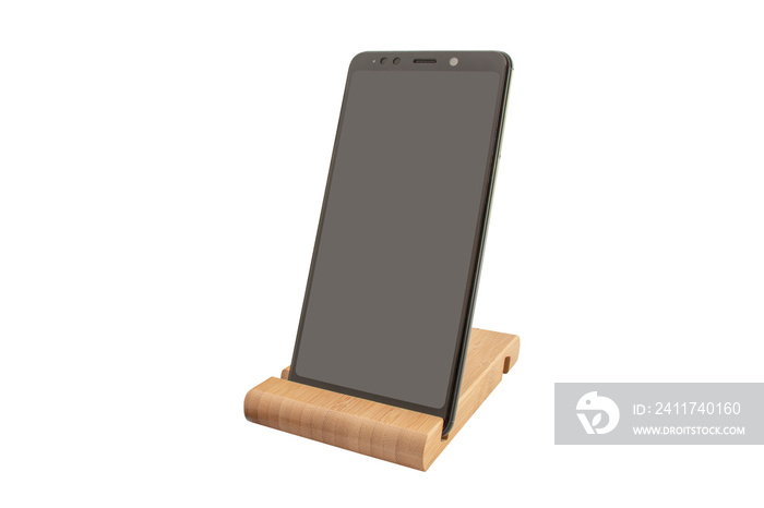 Smartphone on a wooden stand with place for text on display isolated. Modern Mockup of a mobile phone with a dark display. Environmental stands for fixing smartphones. Copy space.