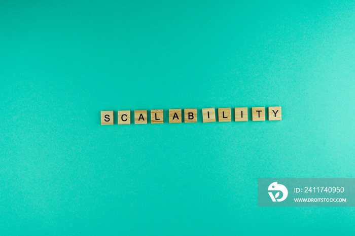 Word Scalability. The phrase is laid out in wooden letters. Top view. Motivation. Blue background. Copy space