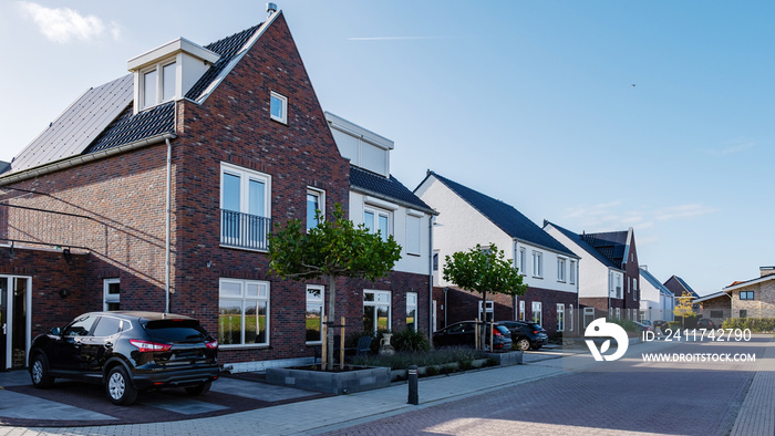 Dutch Suburban area with modern family houses, newly build modern family homes in the Netherlands, dutch family house with a blue sky