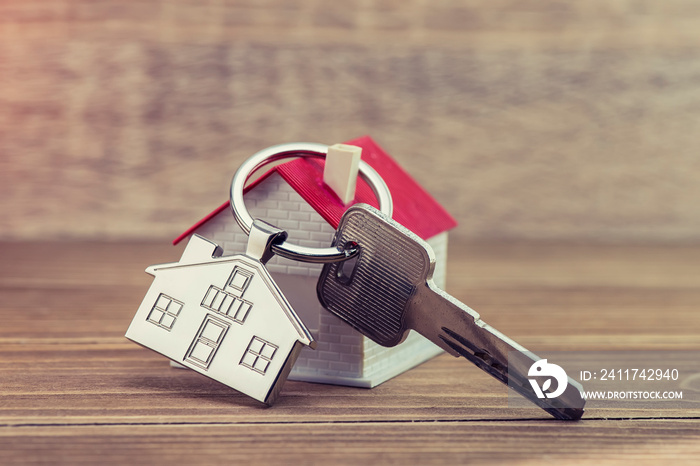 key chain with house symbol and keys on wooden background,Real estate concept