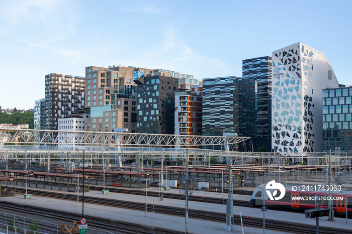 View at Oslo downtown buildings and a train at central railway station. Summer day and a blue sky.