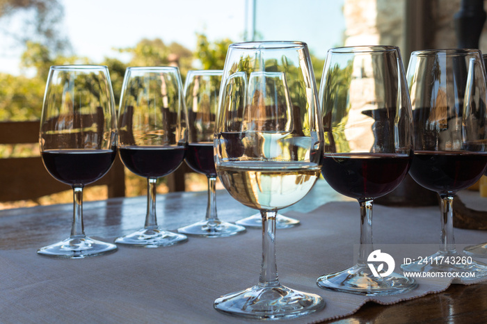 Close up view of wine glasses on table at wine tasting in Urla district of Izmir province in Turkey. It is a sunny summer day.