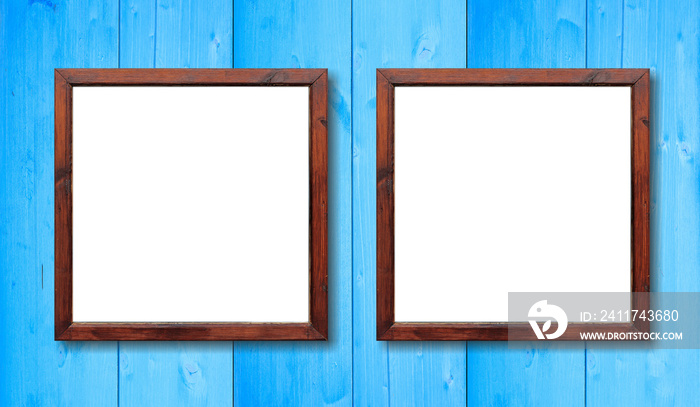 Two empty wooden frames on the wall. White inside and light blue background, space for text.