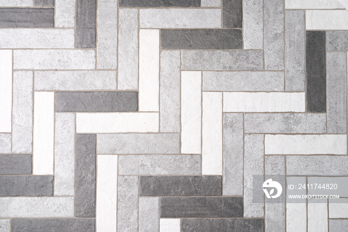 Mosaic floor tiles in rectangles in shades of gray and white closeup