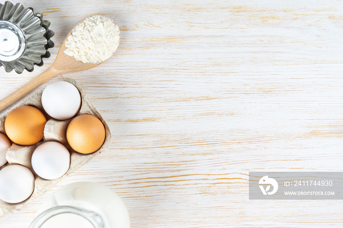 Baking cooking Ingredients background with copy space. Flour, eggs, milk, bakeware on white wooden surface. Top view, flat lay. Mockup menu, banner, header for site, baking concept