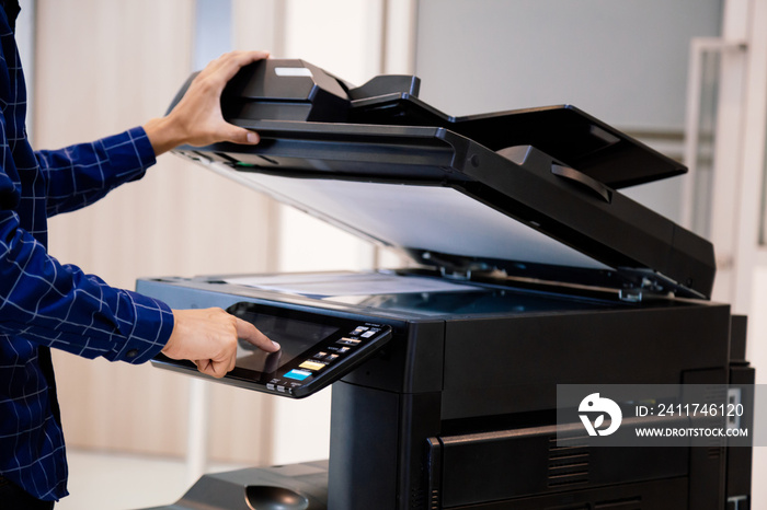 Businessmen press button on the panel for using photocopier or printer for printout and scanning document paper at office.