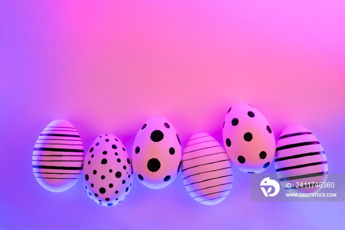 Different graphic hand-painted eggs in Proton Purple neon light. Easter concept. Top view.