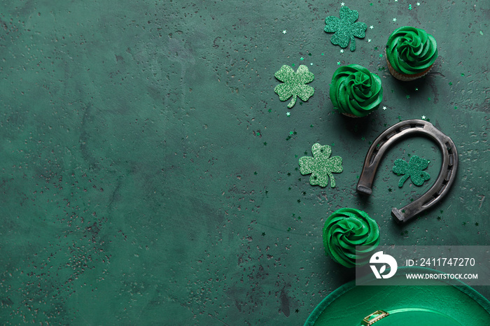 Tasty cupcakes for St. Patrick’s Day, horseshoe and clovers on green background