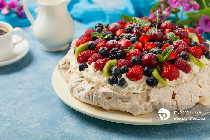 Meringue Pavlova cake with fresh fruit. Front view.