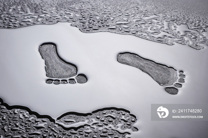 dry traces of human feet in a pool of water.