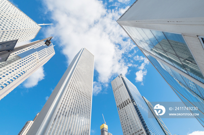 Lookup view of Chicago modern skylines with working crane on building under construction under cloud blue sky. Typical scene from central business district