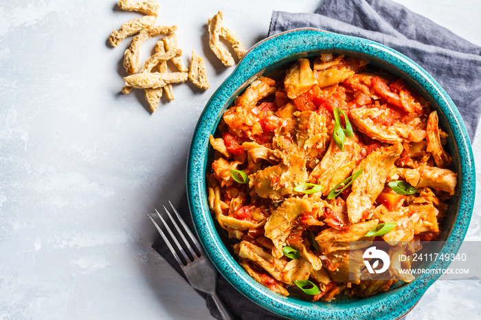 Soy vegan meat in tomato sauce in blue dish on a gray concrete background. Vegan food concept.