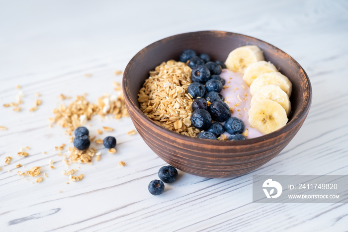 granola with banana and blueberries with pink sweet yogurt