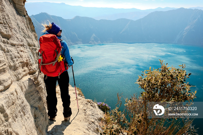 Young tourist girl enjoying spectacular view of green Quilotoa volcaninic lake in Ecuador South America