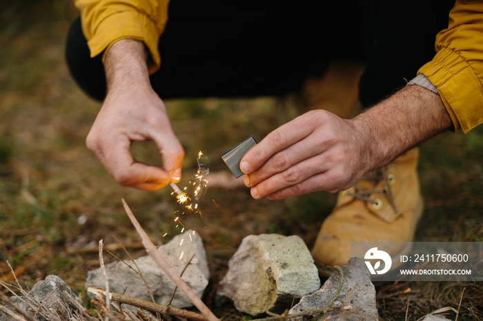 A man makes a fire with a flint