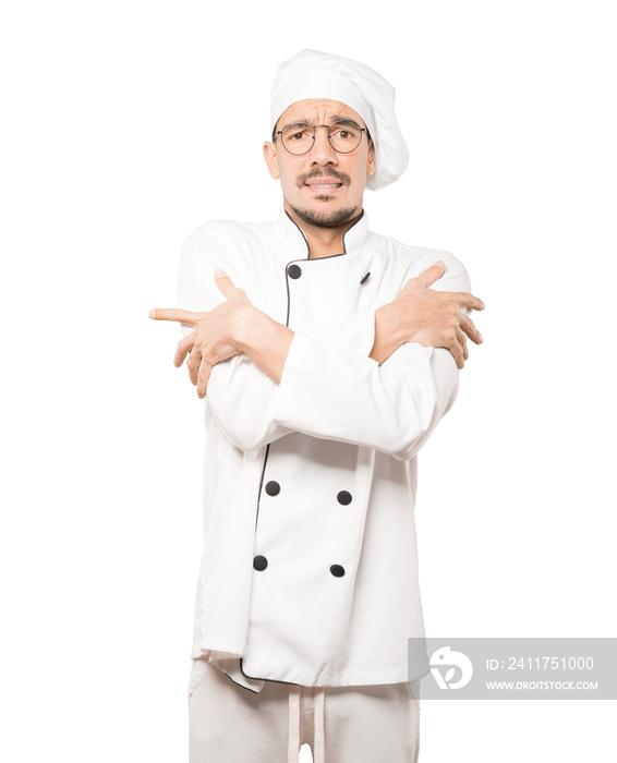 Concerned young chef making a gesture of being cold