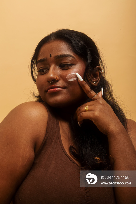 South Asian female solo lifestyle studio portrait skin care shot