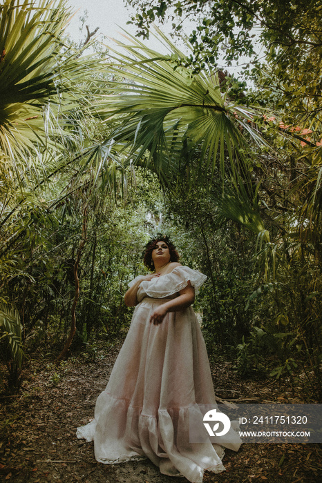 plus size woman stands under tropical plants