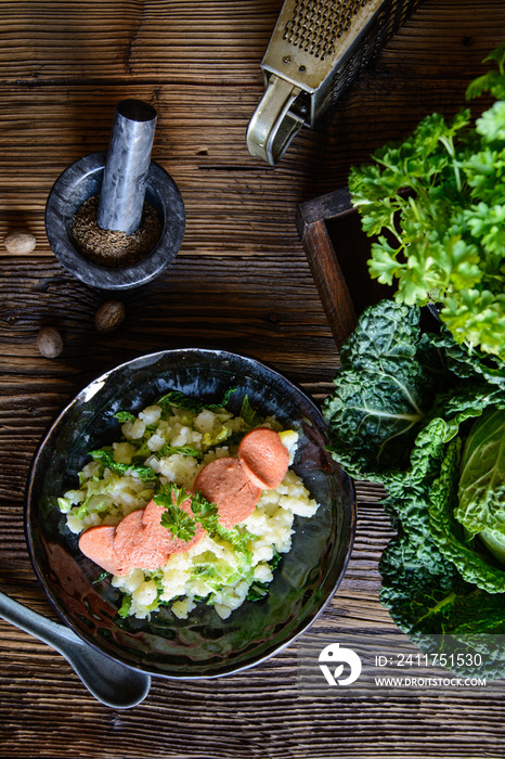 Stamppot, traditional Dutch meal made from mashed potatoes and curly kale, served with sausage slices