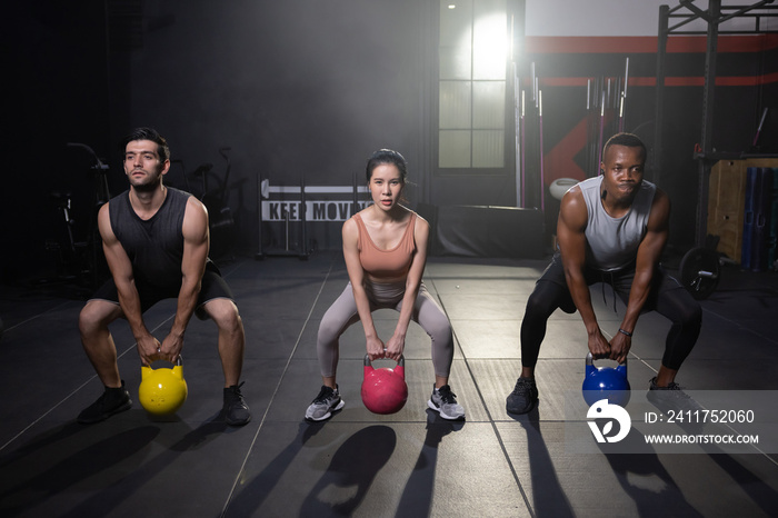 Multi Ethnic People Lifting Kettlebell and Do Squat Training