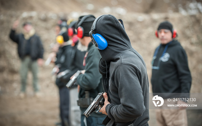 Students group with instructors practice gun shooting on shooting range