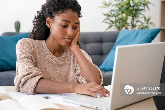 Home education. Black woman watching school lesson from home