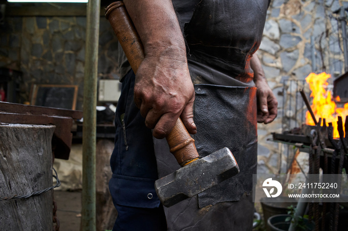 Close up of blacksmith’s hand holding a hammer.