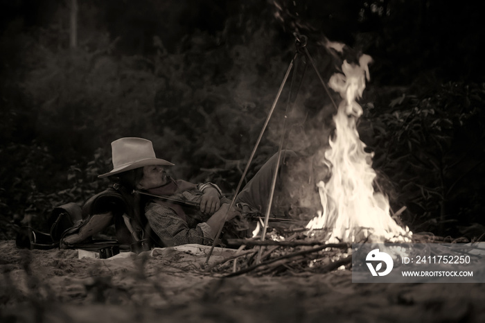 Vintage action shot of a cowboy sleeping in the camp.