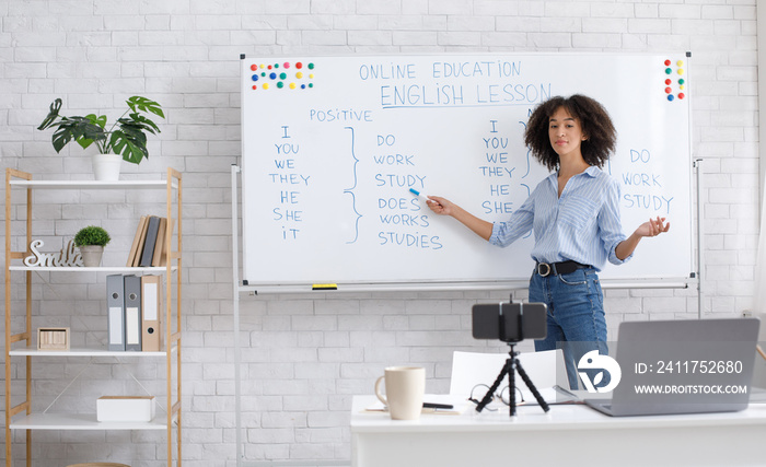 English teacher online at home. Portrait of african american woman, writing on board in classroom