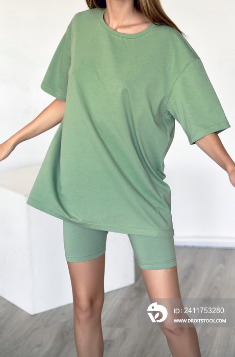 woman wears green oversize t shirt with copy space. indoor studio clothes mockup