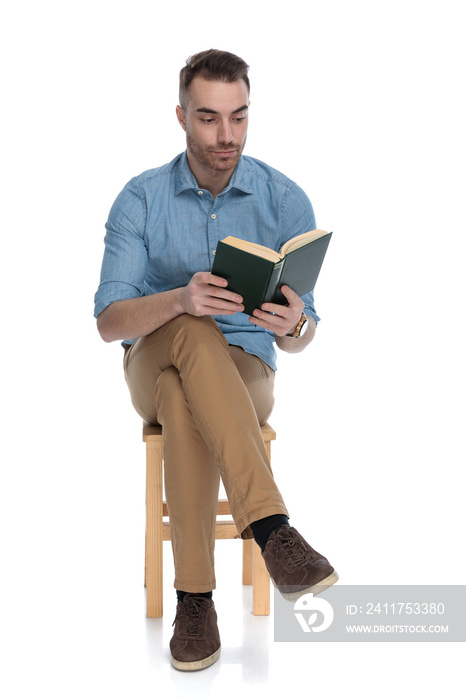 Serious smart casual man focusing on reading a book