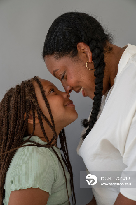 Smiling mother and daughter (6-7) facing each other