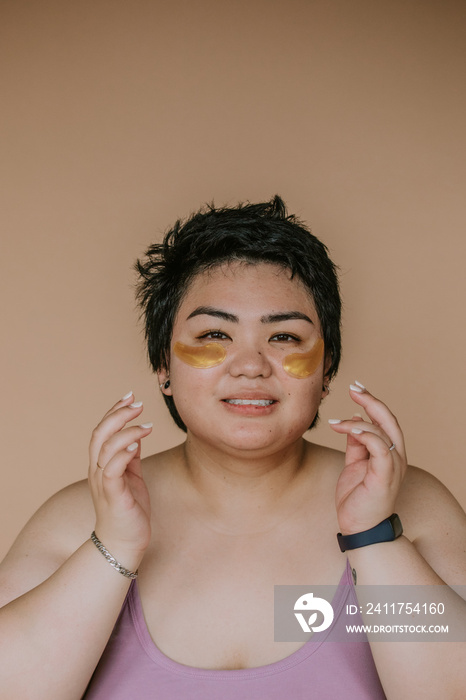 portrait of a plus size woman with eye pads smiling