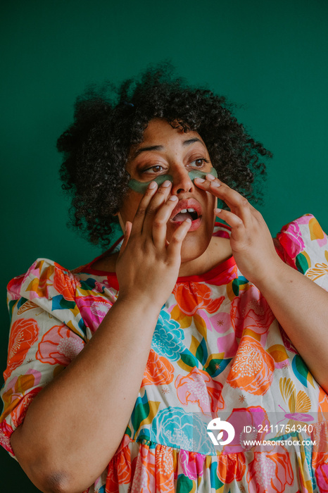 closeup of a plus size black person applying cooling eye pads